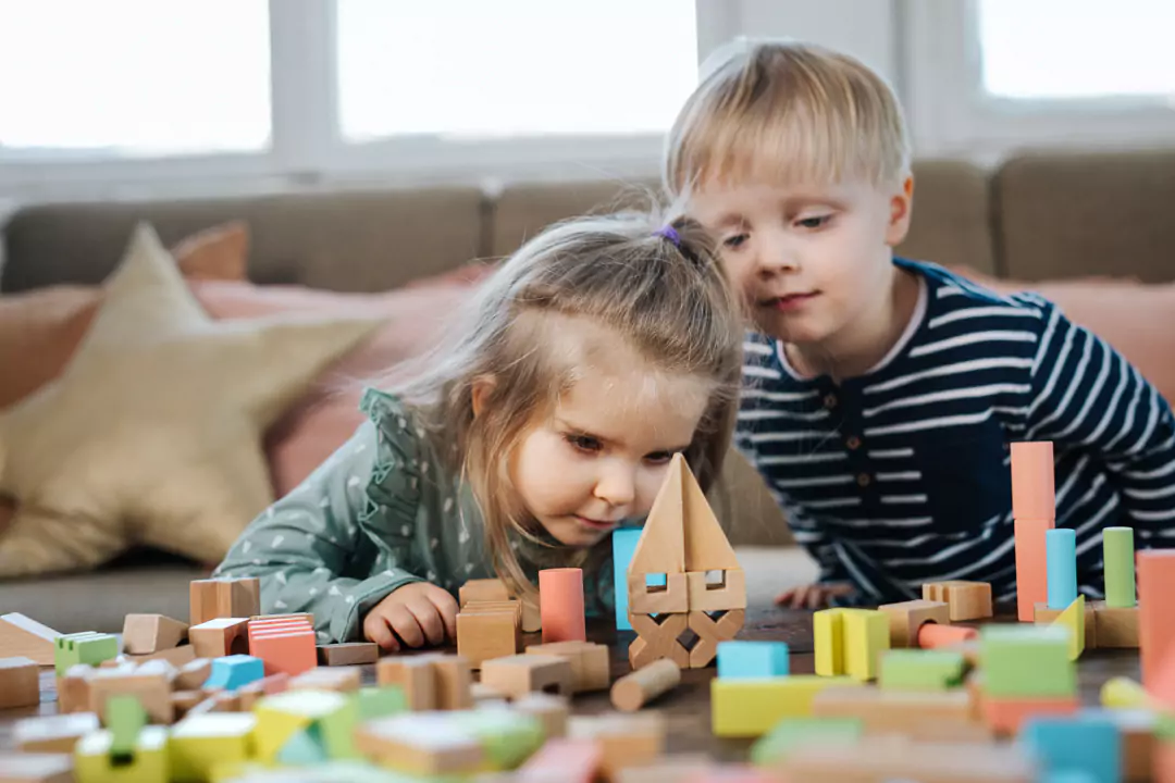 Dzieci bawiące się zabawkami drewnianymi od Trefla